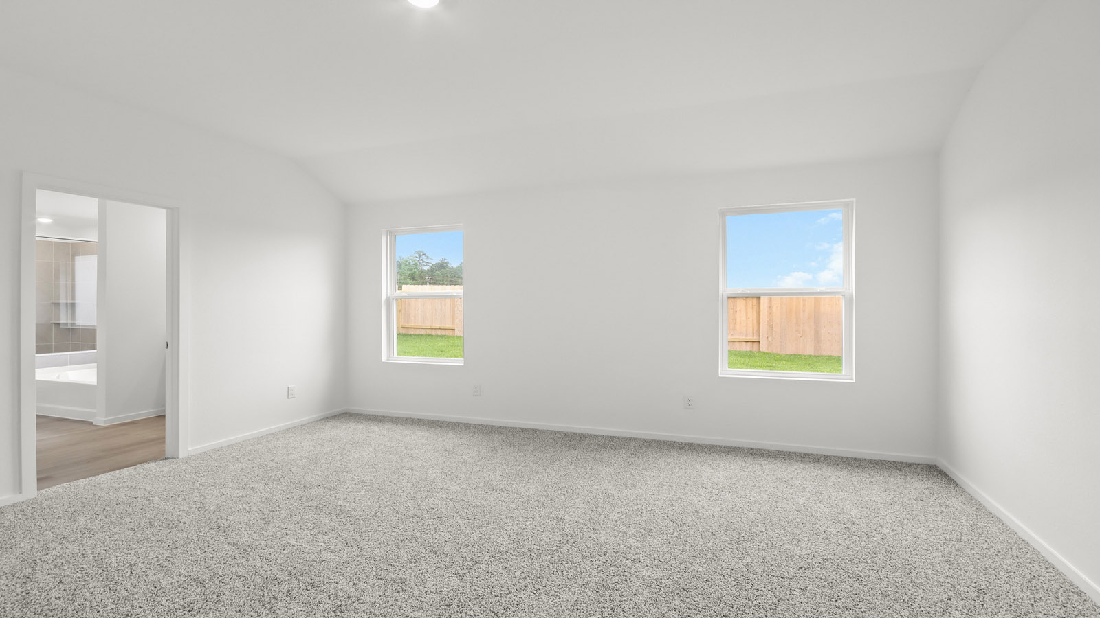 Large Primary bedroom with shag carpet flooring and bright window