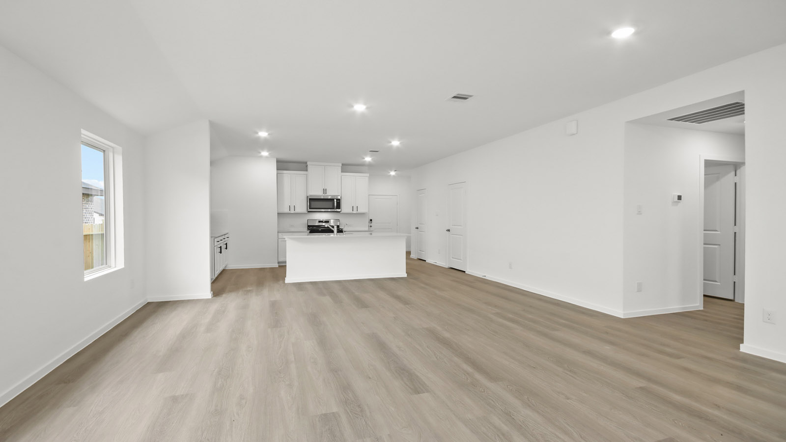 Spacious living area with vinyl flooring and bright windows in Magnolia TX