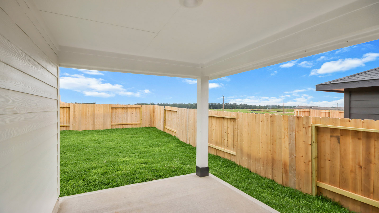 covered patio with jamies hardie siding and overhead lighting