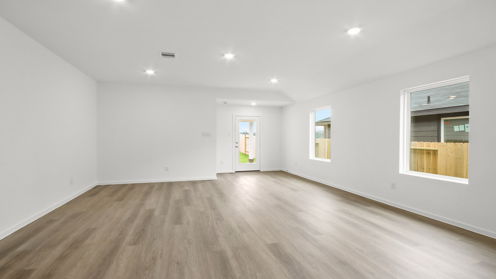 Spacious living area with vinyl flooring and bright windows in Magnolia TX
