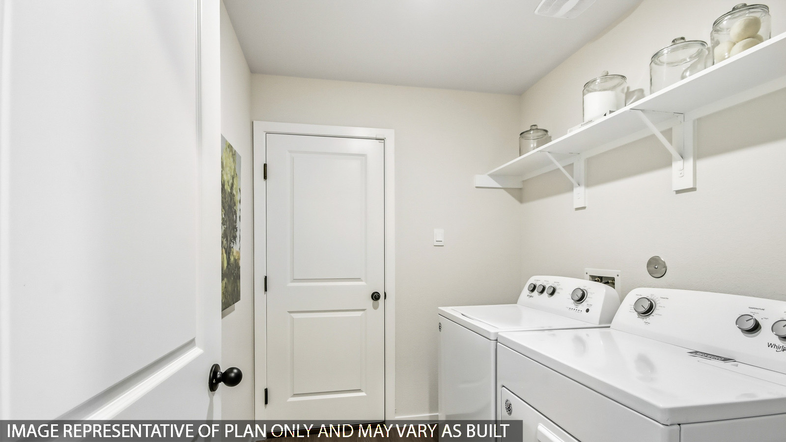 Utility room with storage located off the entry hallway and garage door