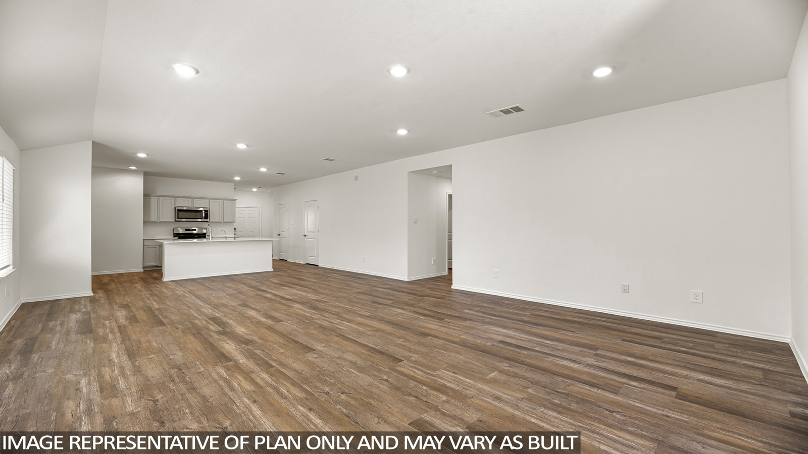 Open living room with windows, white walls, and vinyl wood flooring.