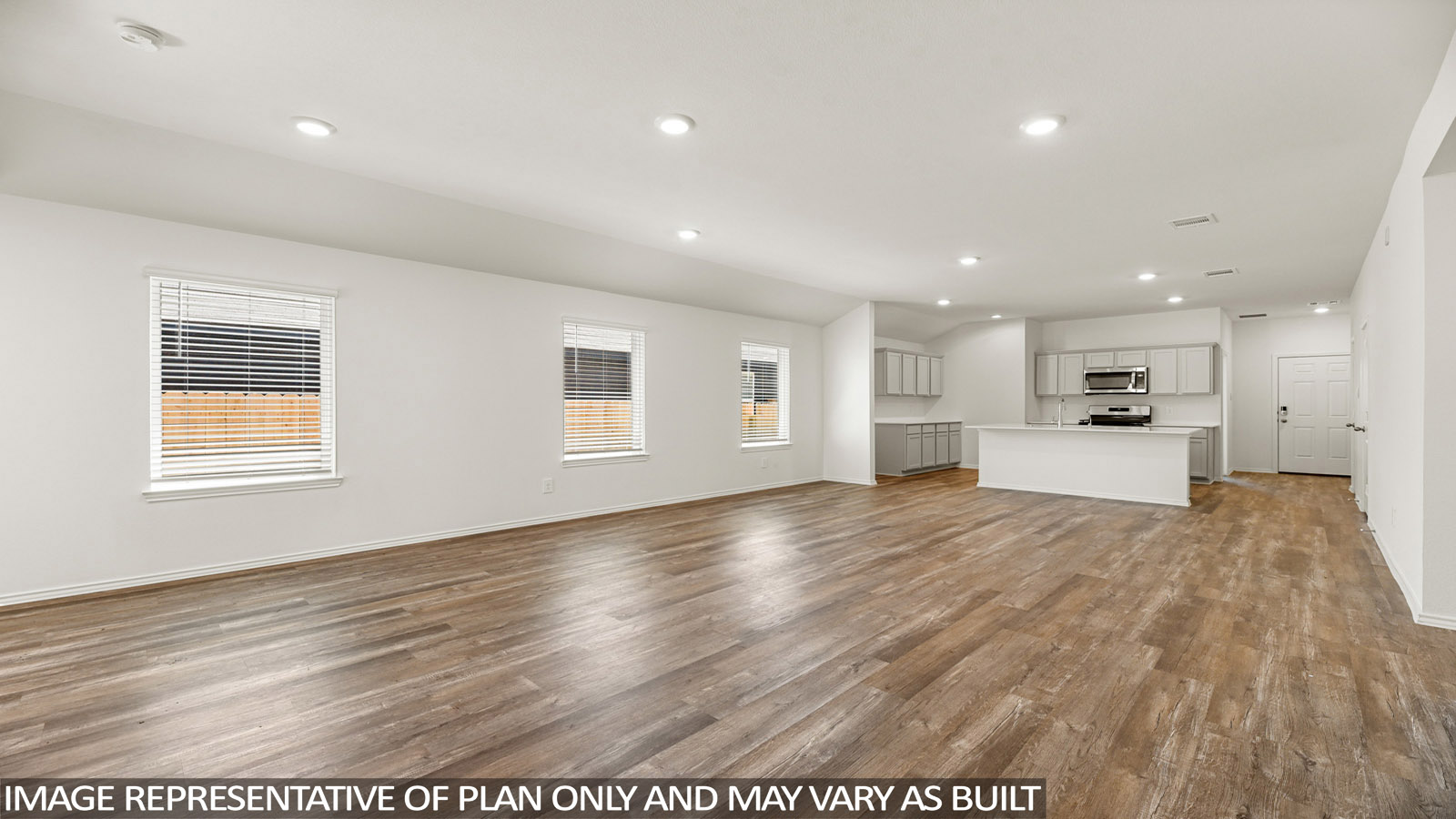 Open living room with windows, white walls, and vinyl wood flooring.