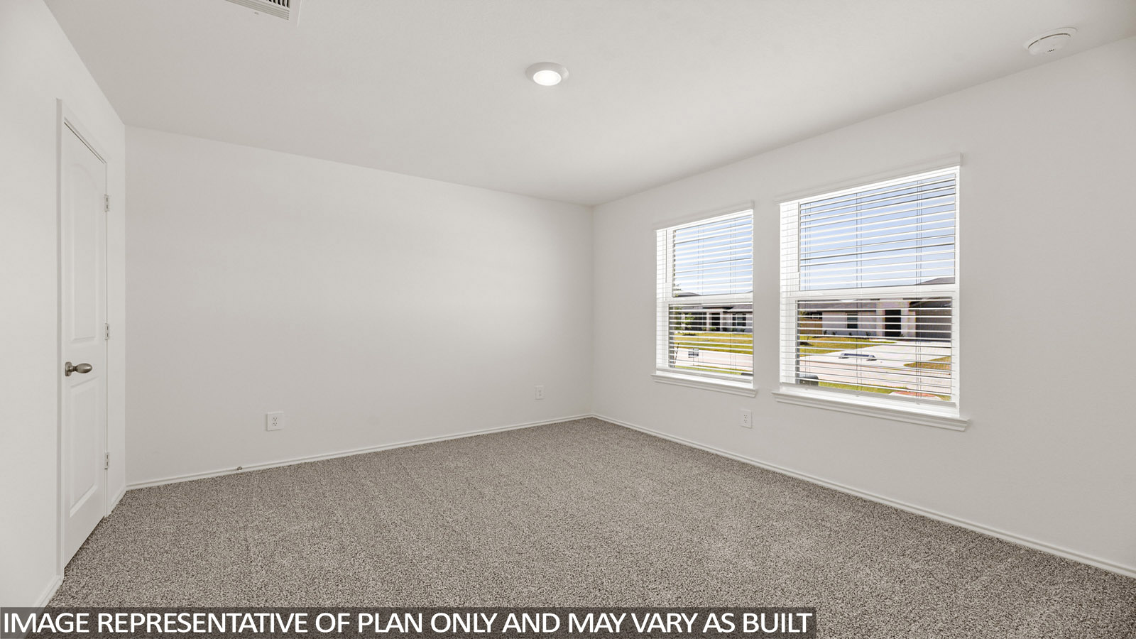 Secondary bedroom with windows, white walls, and light carpet.