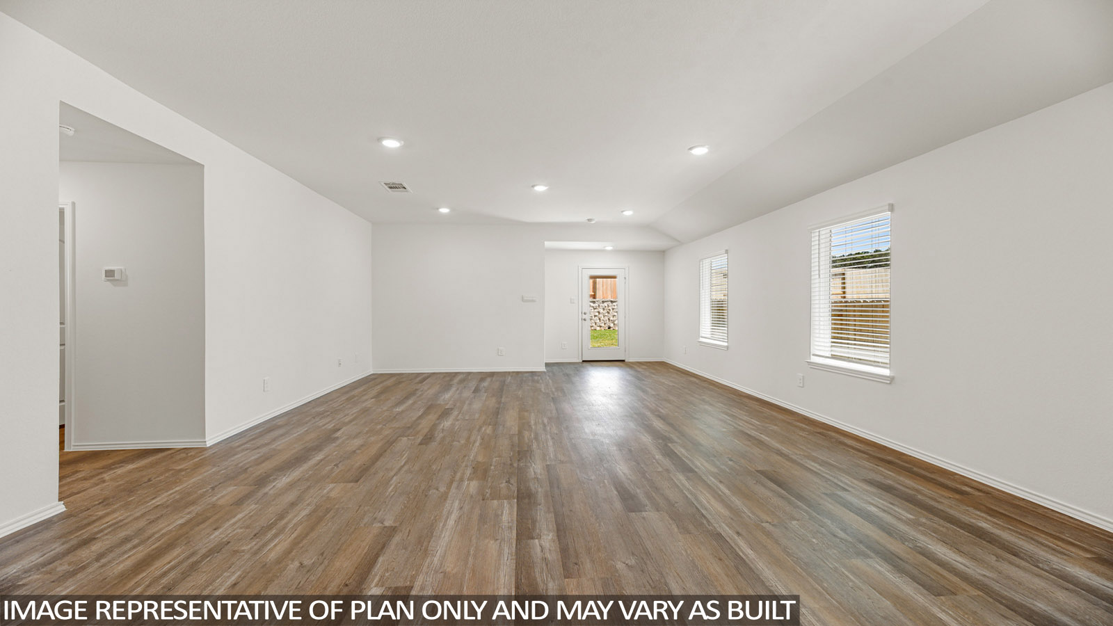 Open living room with windows, white walls, and vinyl wood flooring.