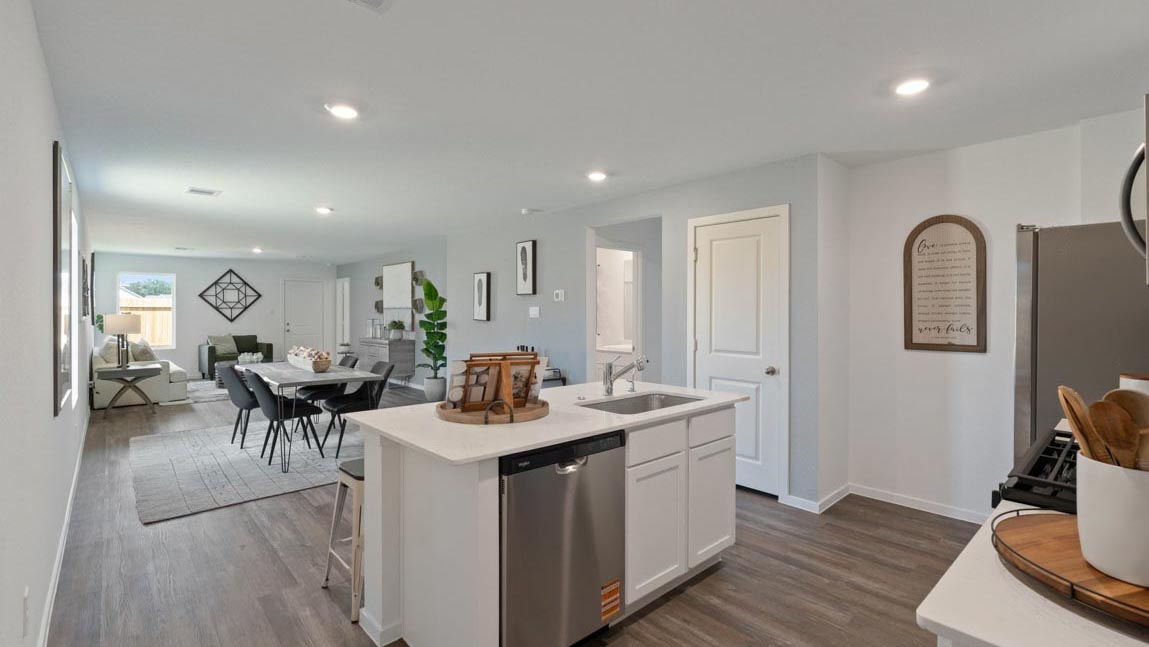 Kitchen with quartz countertops and marden hardware and an island and vinyl floor