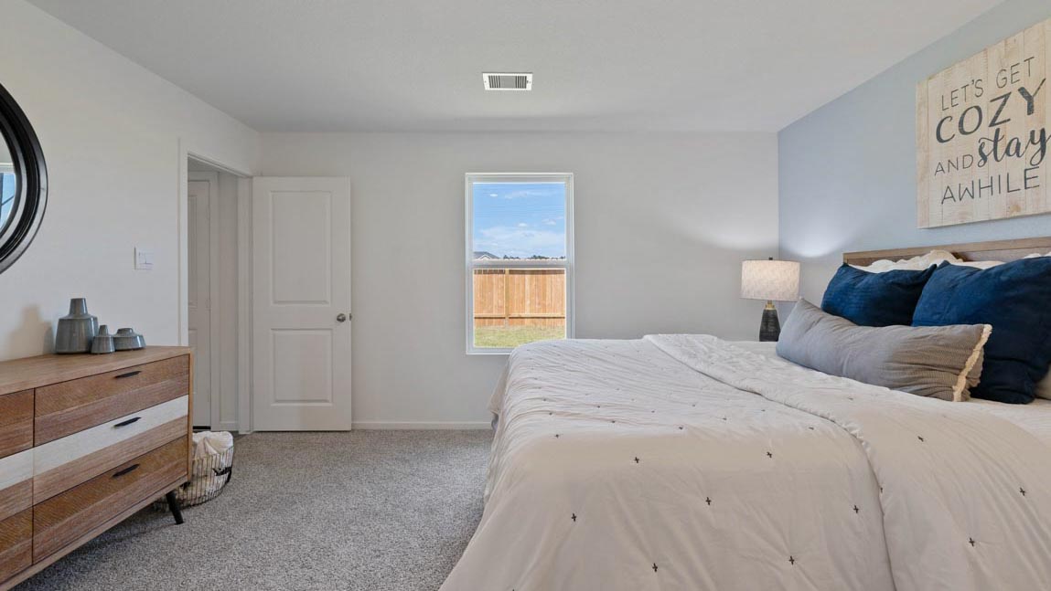 Large Primary bedroom with shag carpet flooring and bright window