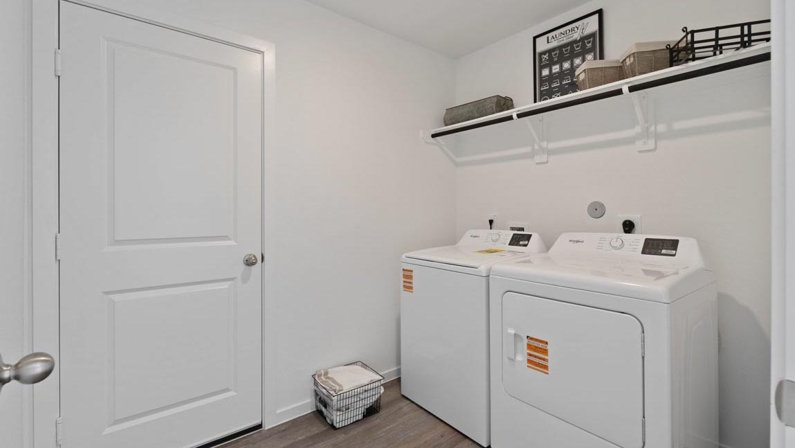 Utility room with storage located off the entry hallway and garage door