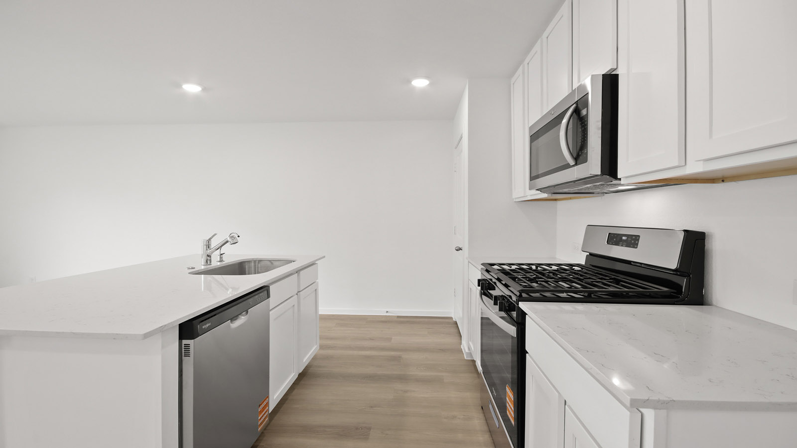 Kitchen with quartz countertops and marden hardware and an island and vinyl floor