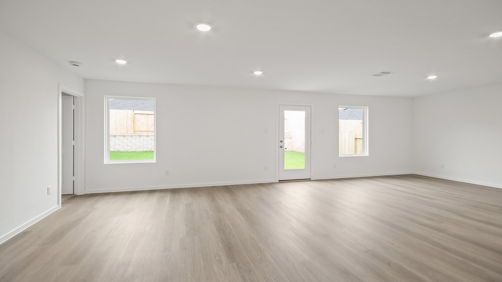Spacious living area with vinyl flooring and bright windows in Magnolia TX
