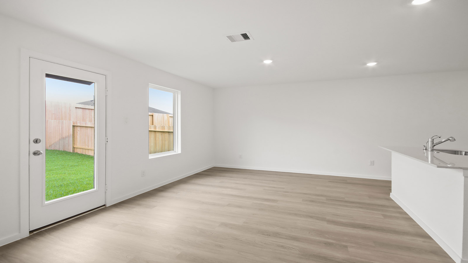 Spacious living area with vinyl flooring and bright windows in Magnolia TX