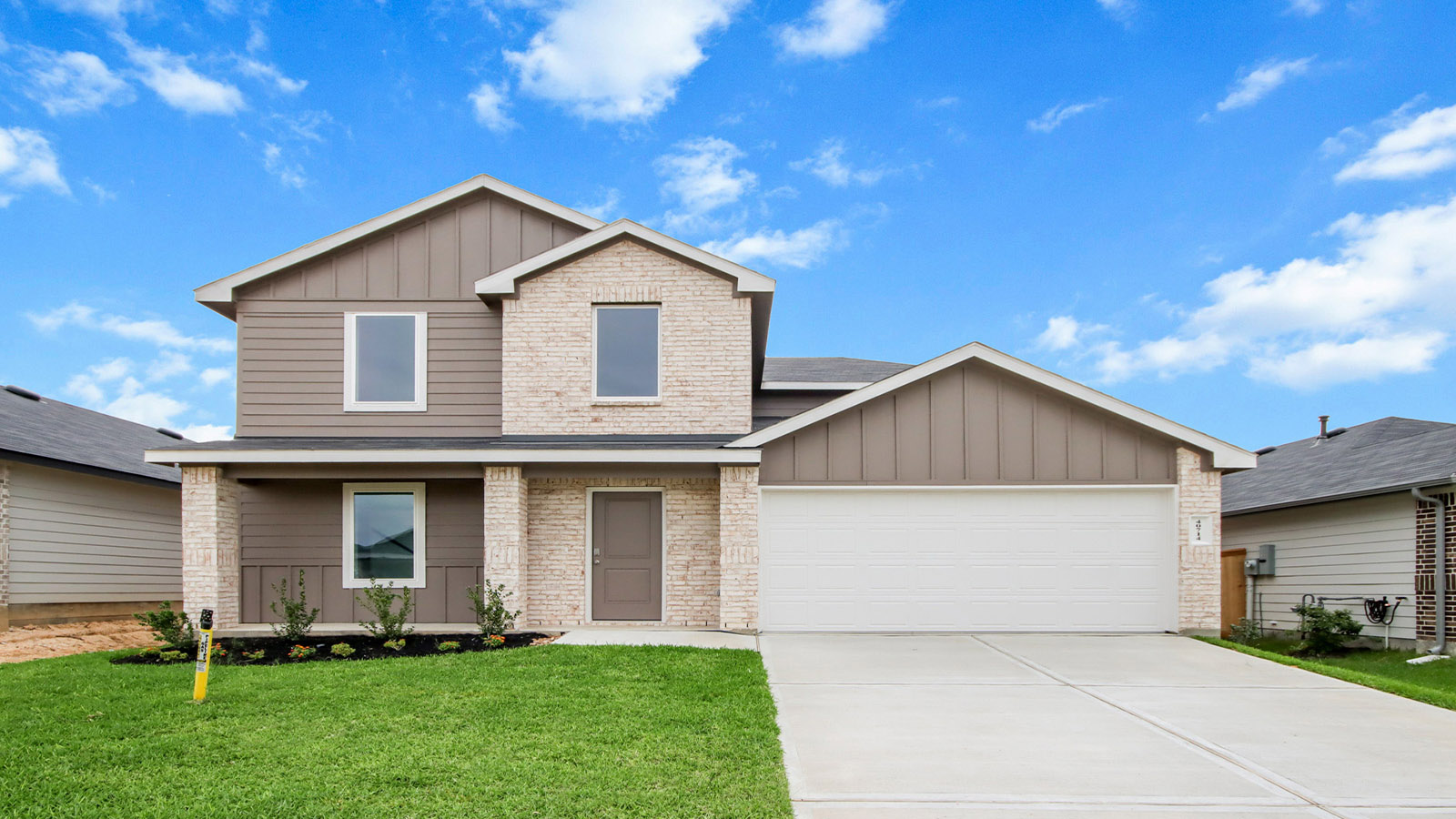 Two story home with two car garage with brick and siding in Magnolia TX