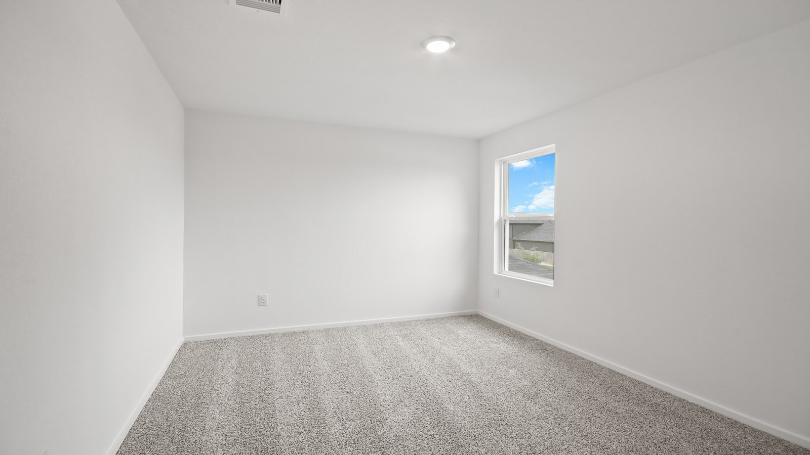 Second level secondary bedroom with carpet flooring and bright window
