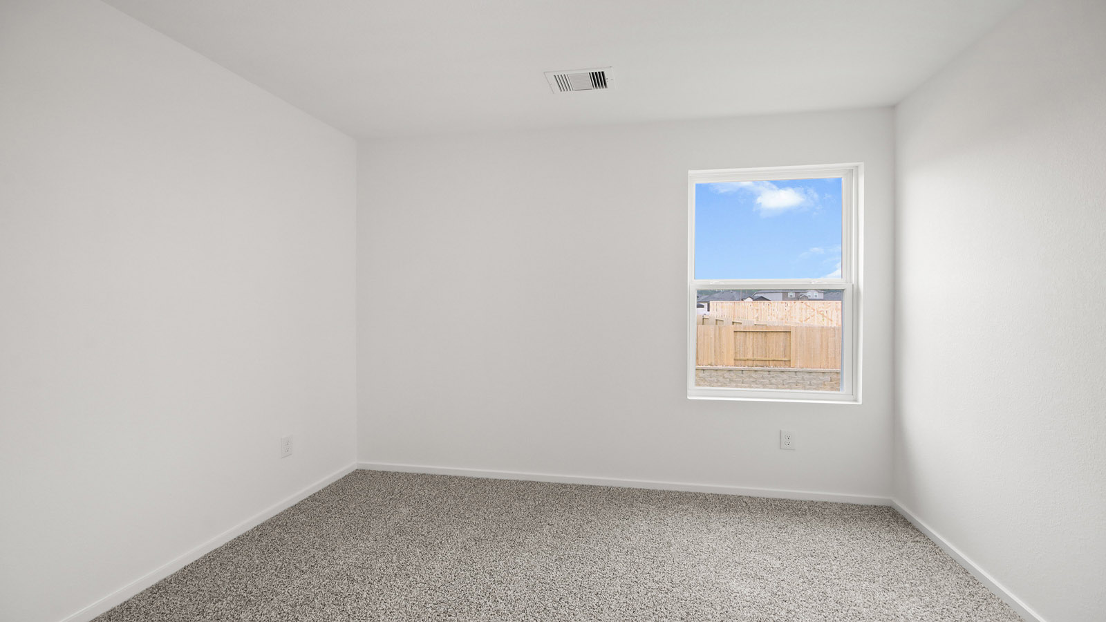 Second level secondary bedroom with carpet flooring and bright window