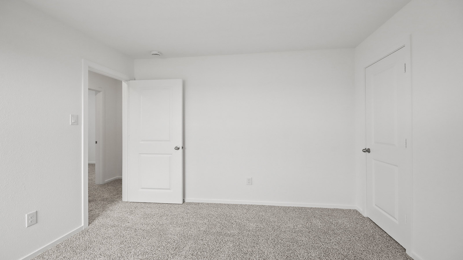 Second level secondary bedroom with carpet flooring and bright window