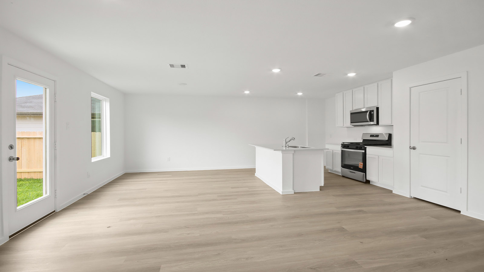 Spacious living area with vinyl flooring and bright windows in Magnolia TX