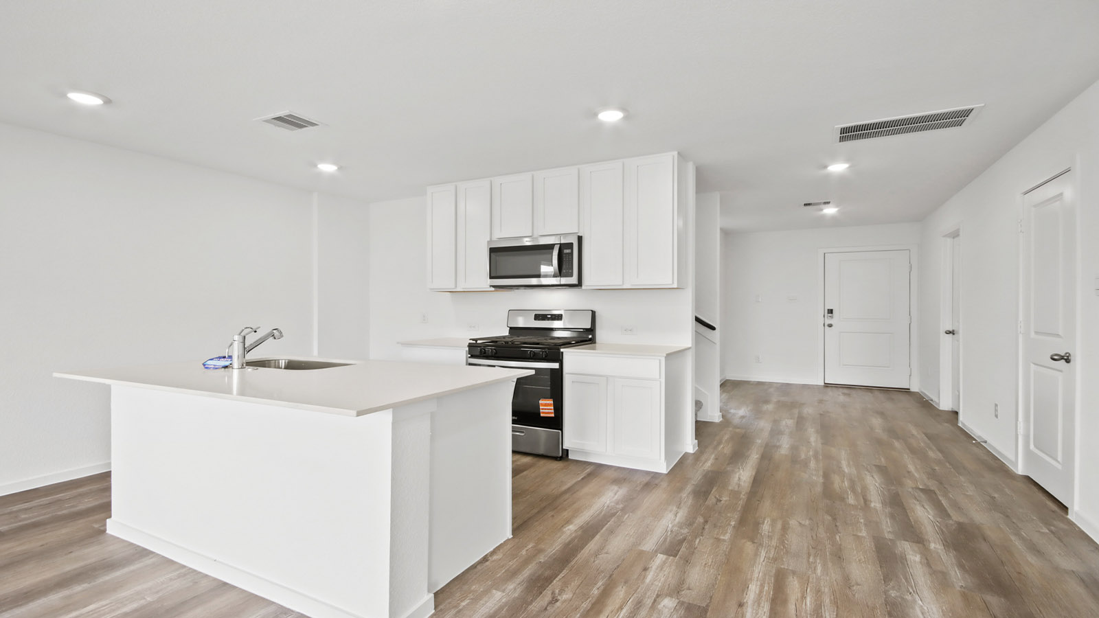 Kitchen with quartz countertops and marden hardware and an island and vinyl floor