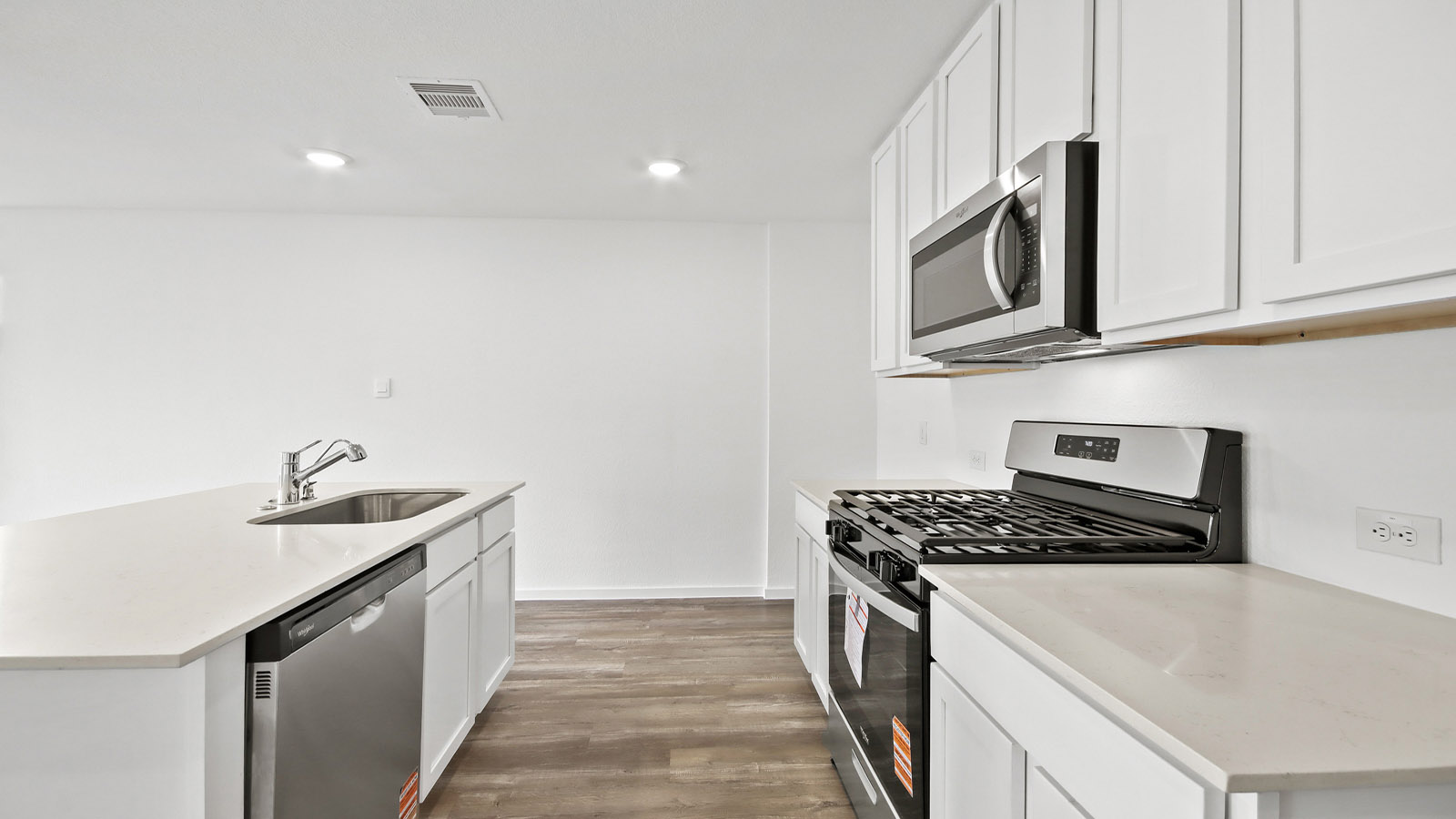 Kitchen with quartz countertops and marden hardware and an island and vinyl floor