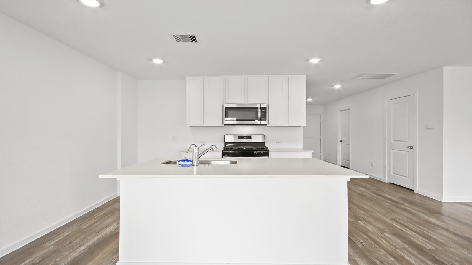 Kitchen with quartz countertops and marden hardware and an island and vinyl floor