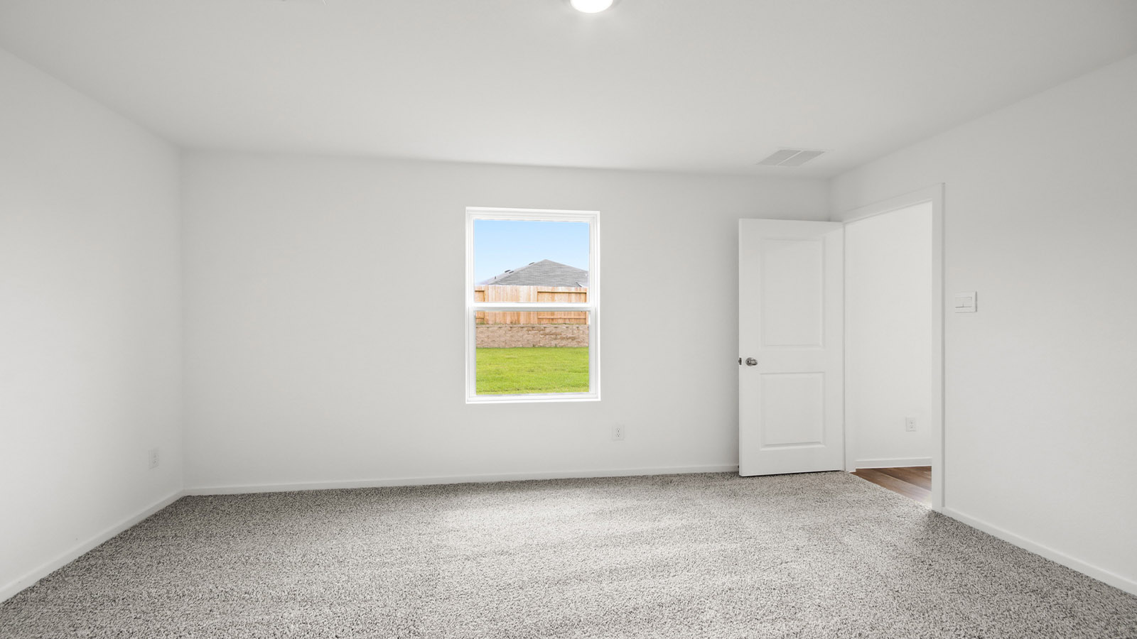 Large Primary bedroom with shag carpet flooring and bright window