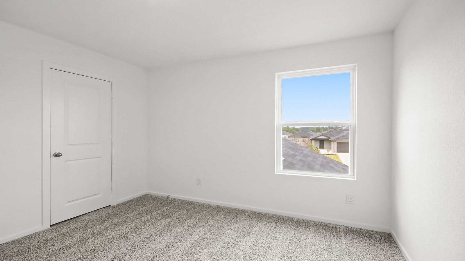Second level secondary bedroom with carpet flooring and bright window