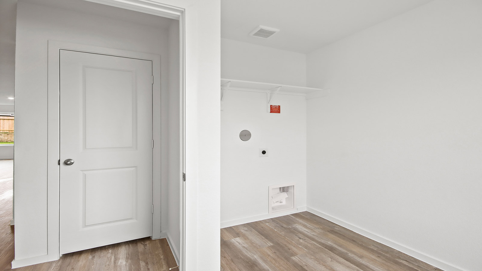 Utility room with storage located off the entry hallway and garage door