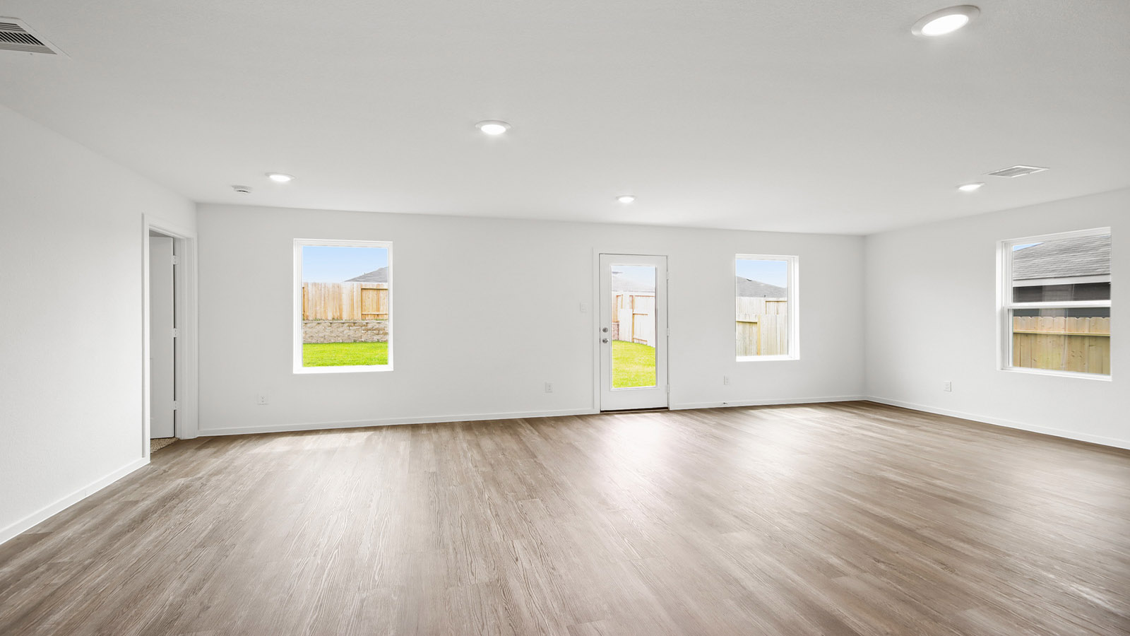 Spacious living area with vinyl flooring and bright windows in Magnolia TX