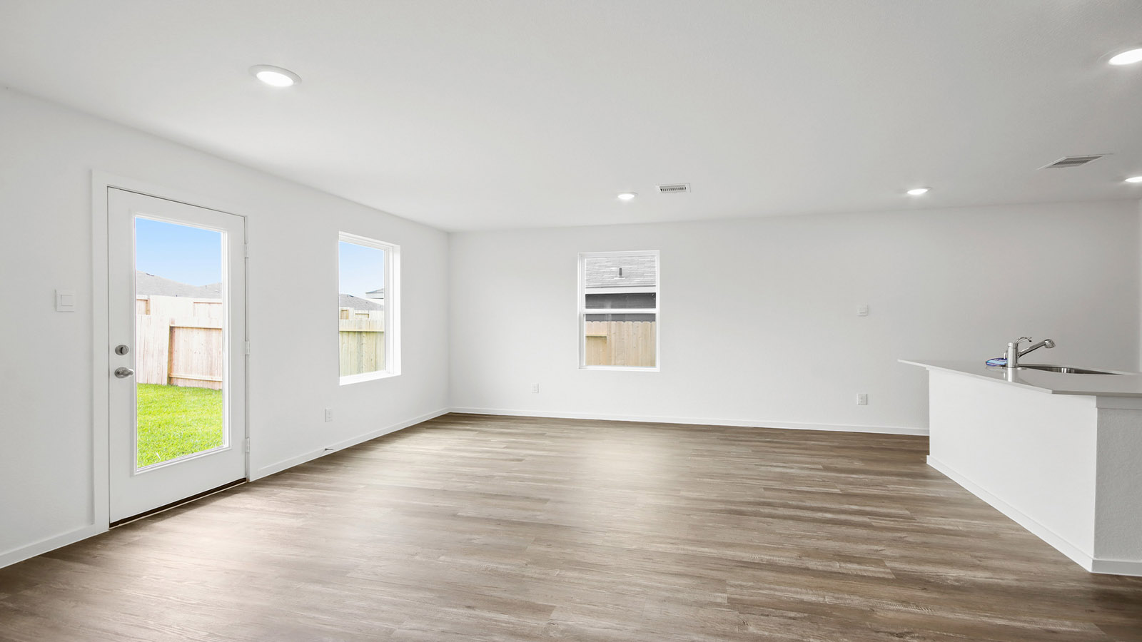 Spacious living area with vinyl flooring and bright windows in Magnolia TX