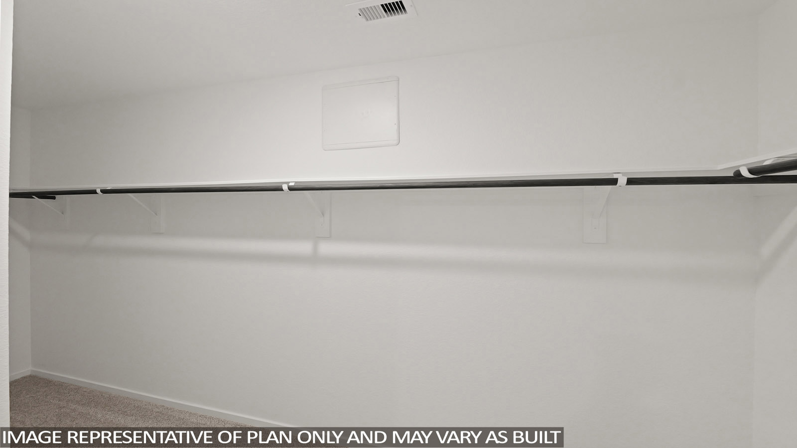 Primary closet with white walls and vinyl wood flooring.