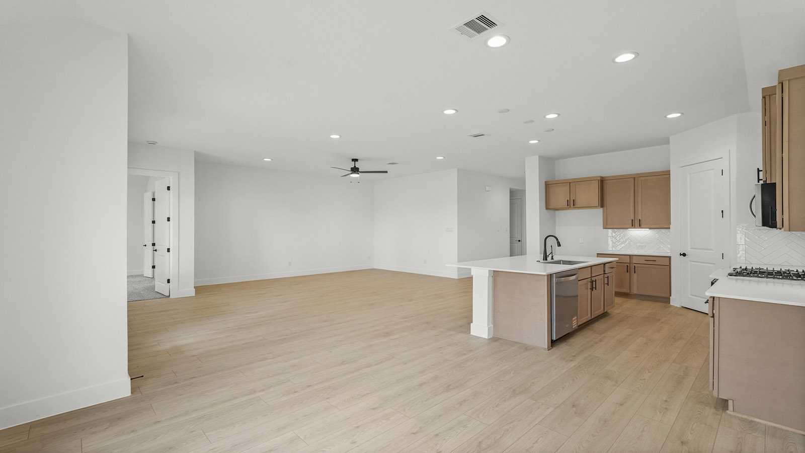 Kitchen with quartz countertops and marden hardware and an island and vinyl floor