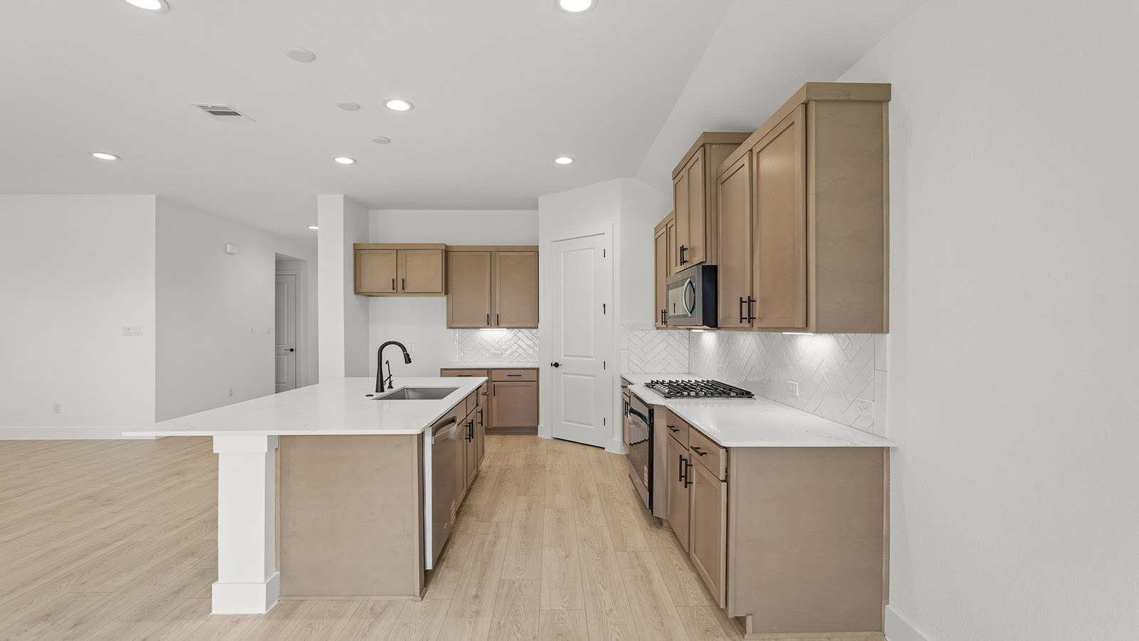 Kitchen with quartz countertops and marden hardware and an island and vinyl floor