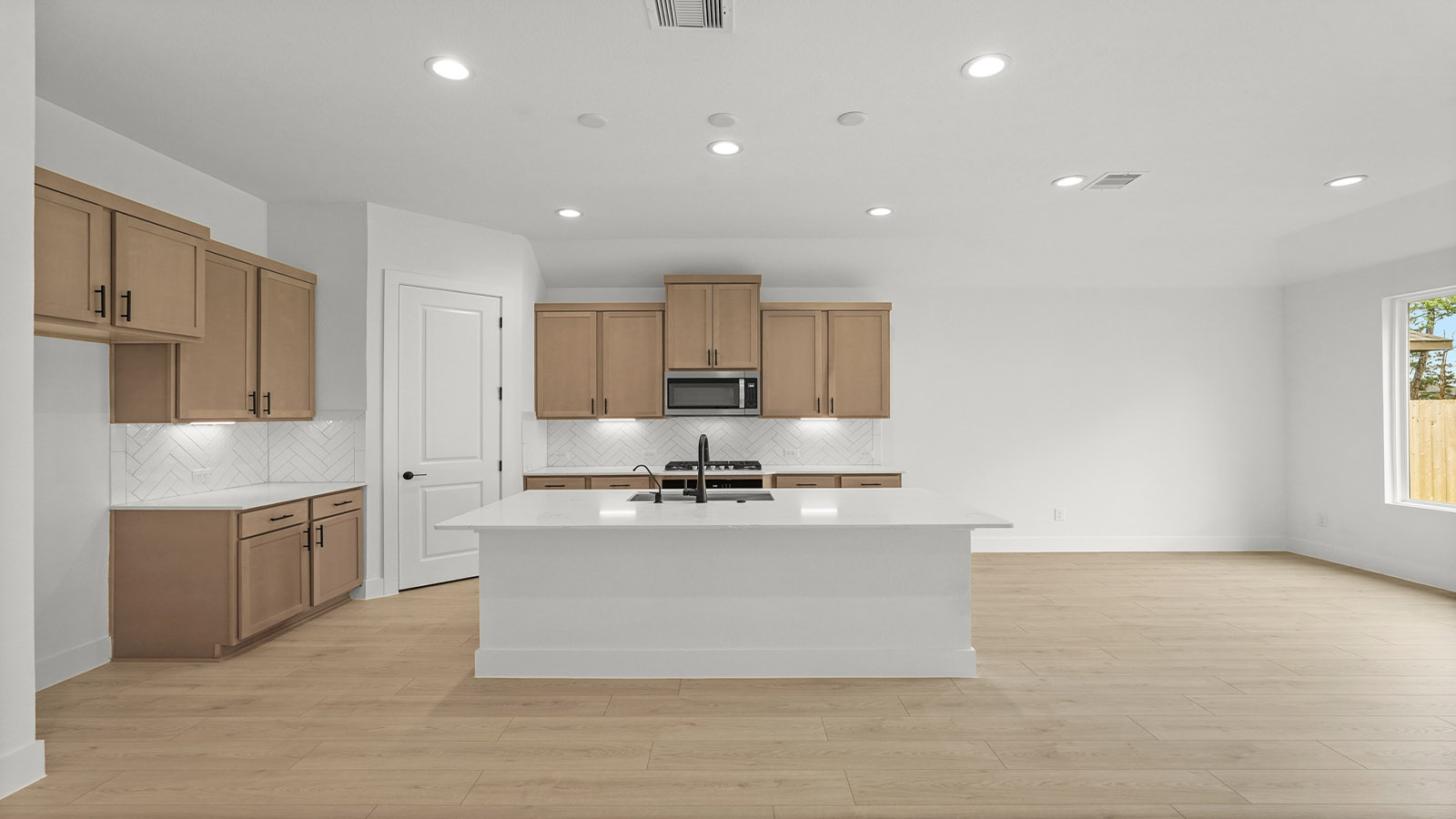 Kitchen with quartz countertops and marden hardware and an island and vinyl floor