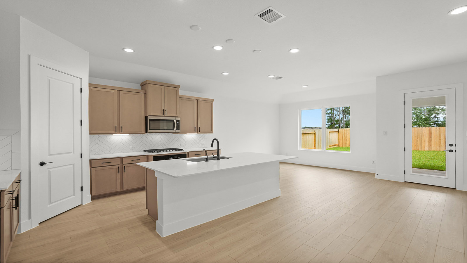 Kitchen with quartz countertops and marden hardware and an island and vinyl floor