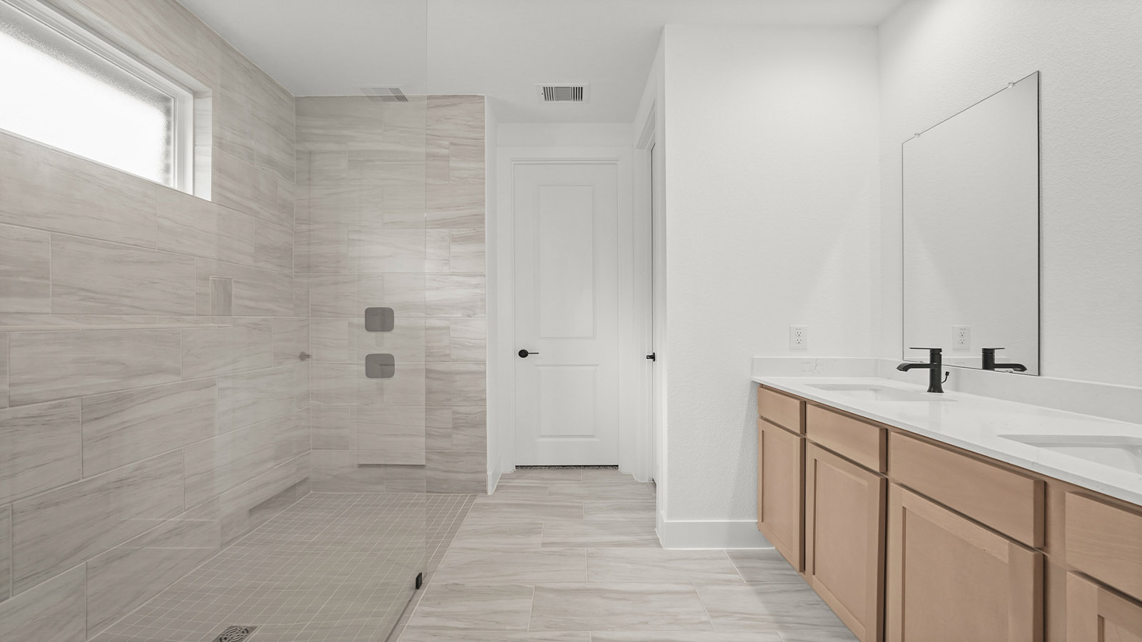 Primary bathroom with double sinks with quartz counter tops in Magnolia TX