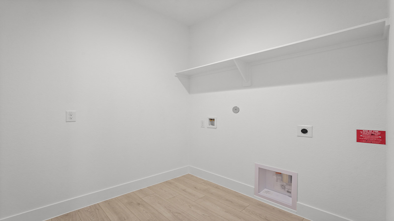 Utility room with storage located off the entry hallway and garage door