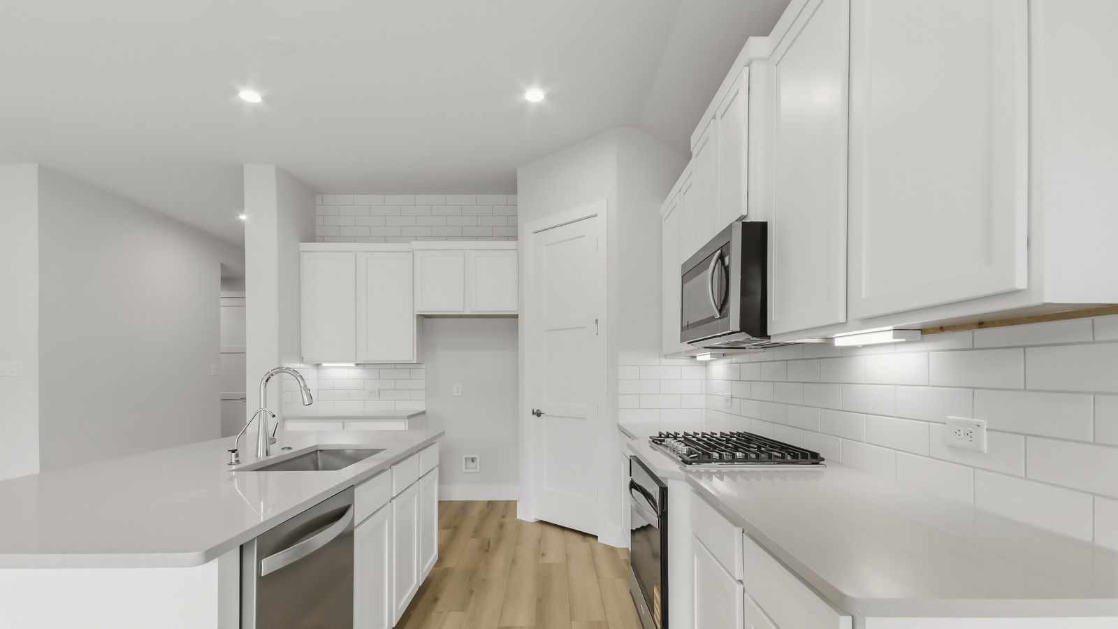Kitchen with quartz countertops and marden hardware and an island and vinyl floor