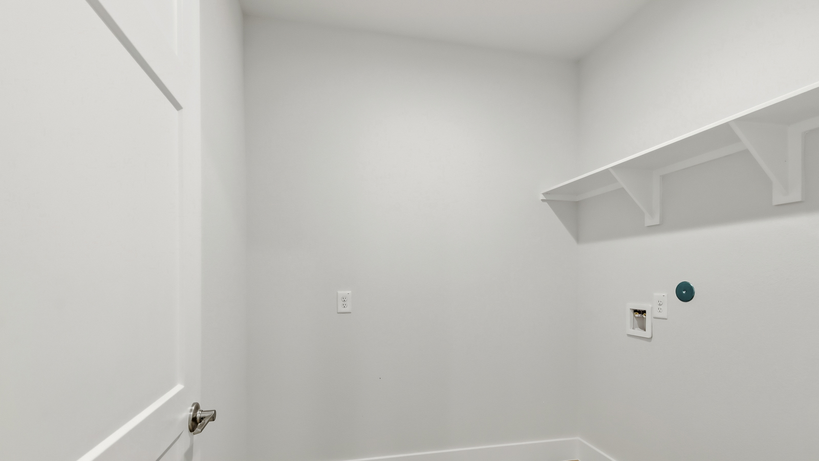 Utility room with storage located off the entry hallway and garage door
