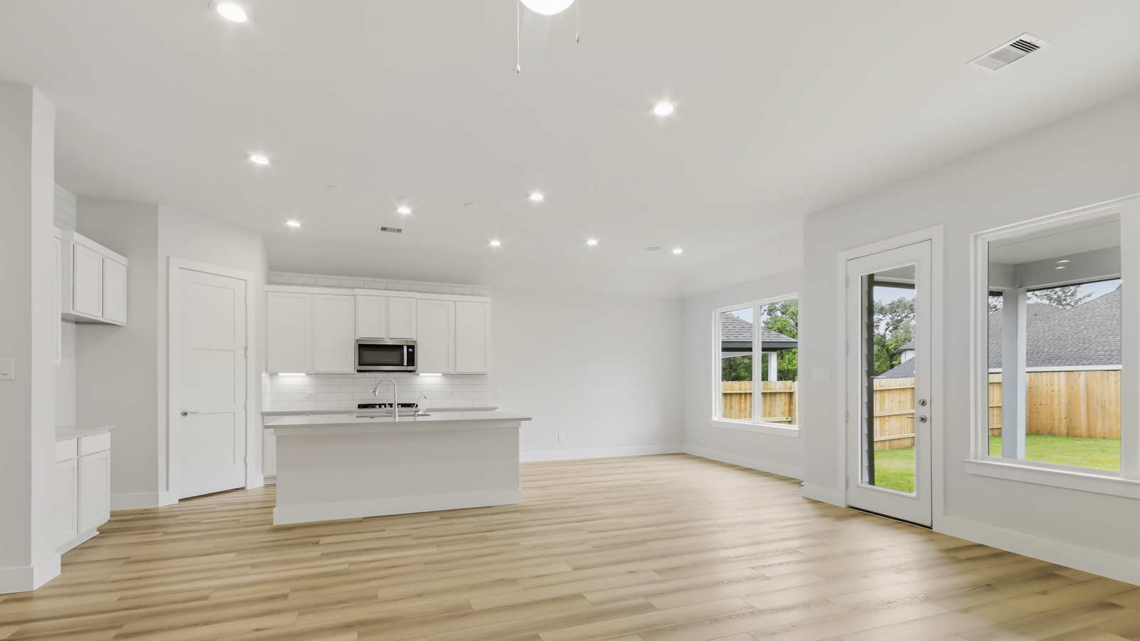 Kitchen with quartz countertops and marden hardware and an island and vinyl floor