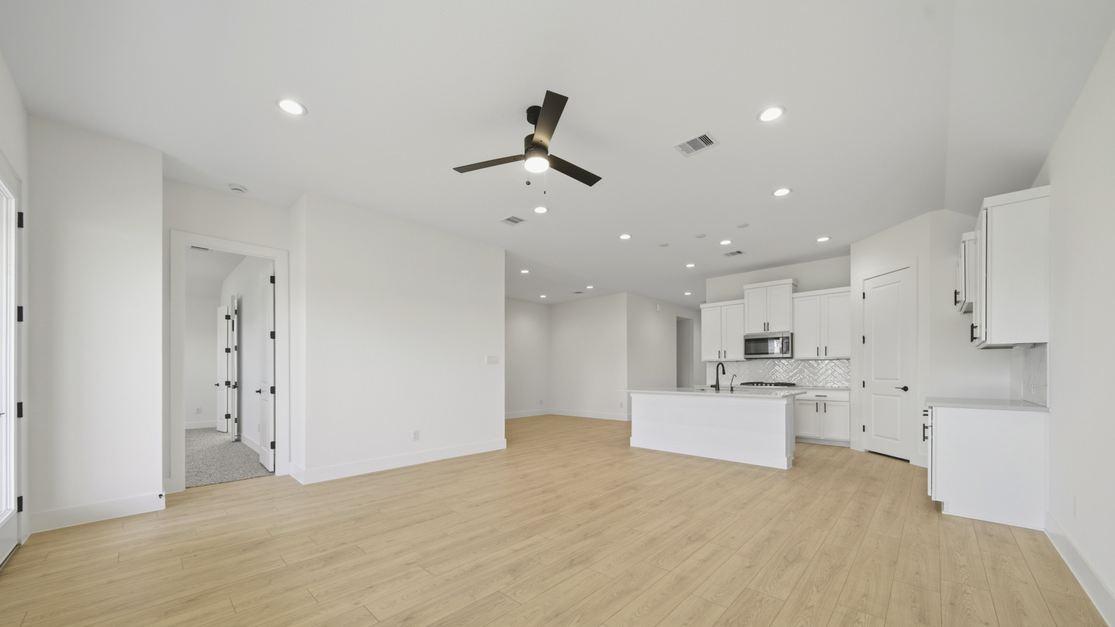 Kitchen with quartz countertops and marden hardware and an island and vinyl floor