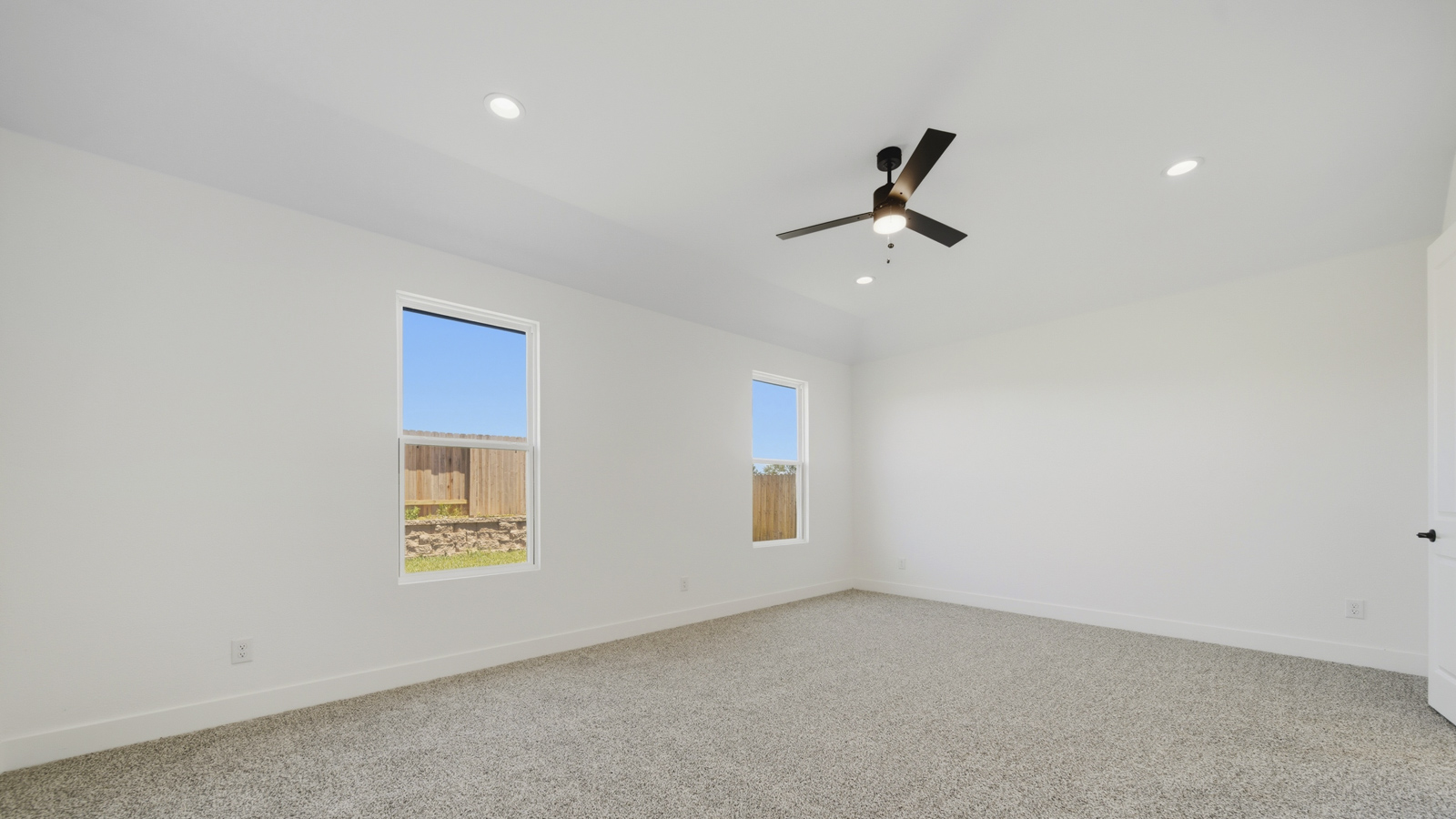 Large Primary bedroom with shag carpet flooring and bright window