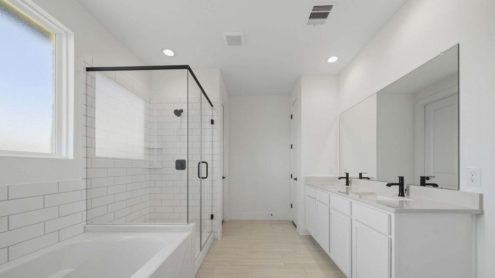 Primary bathroom with soaker tub and tile shower with semi frameless glass in Magnolia TX