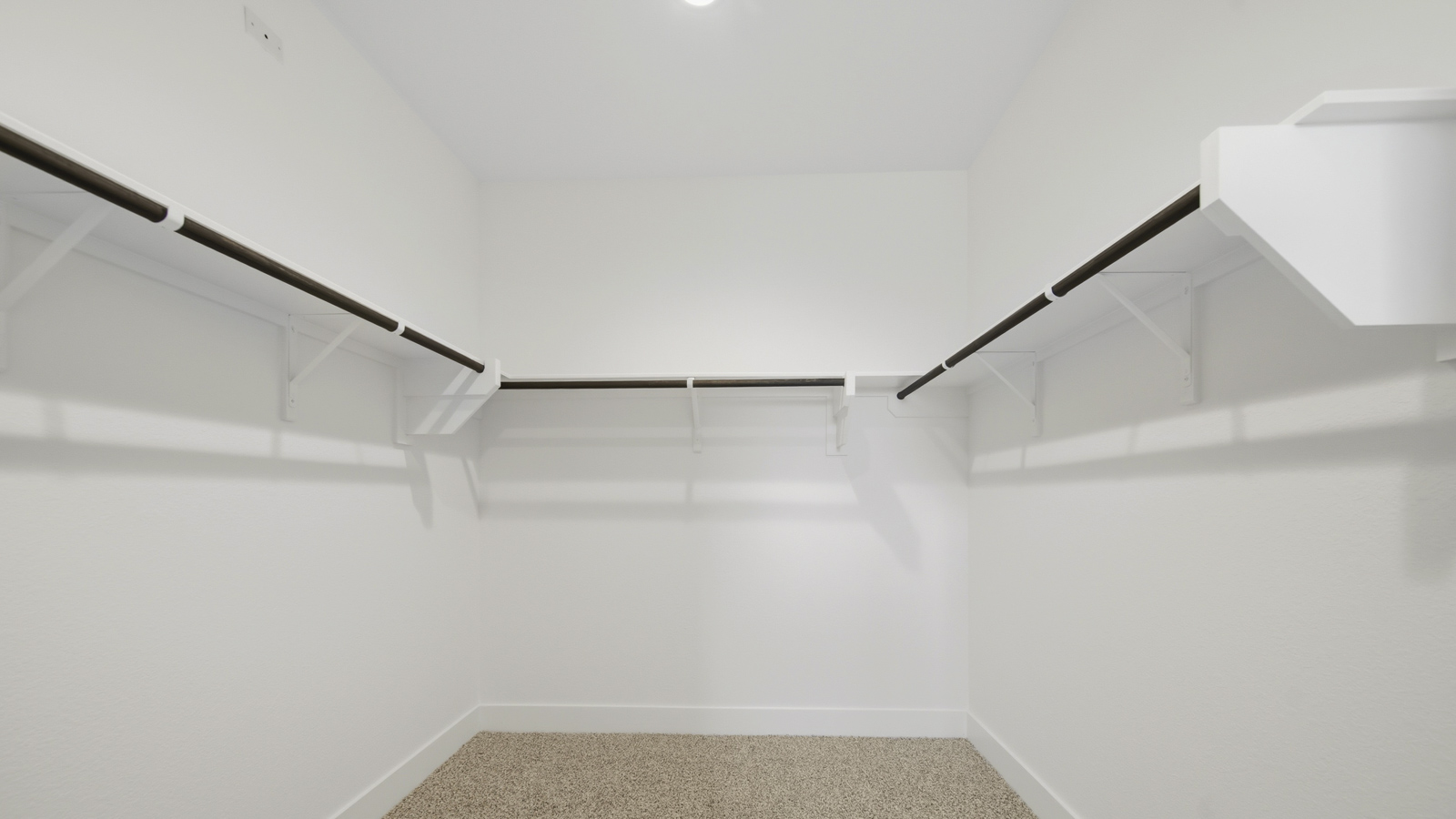 Primary bedroom walk-in closet with carpet flooring in Mill Creek community in Magnolia TX
