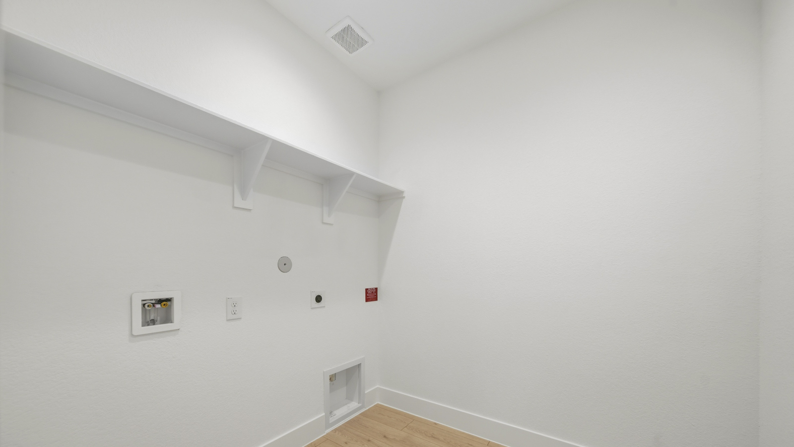 Utility room with storage located off the entry hallway and garage door