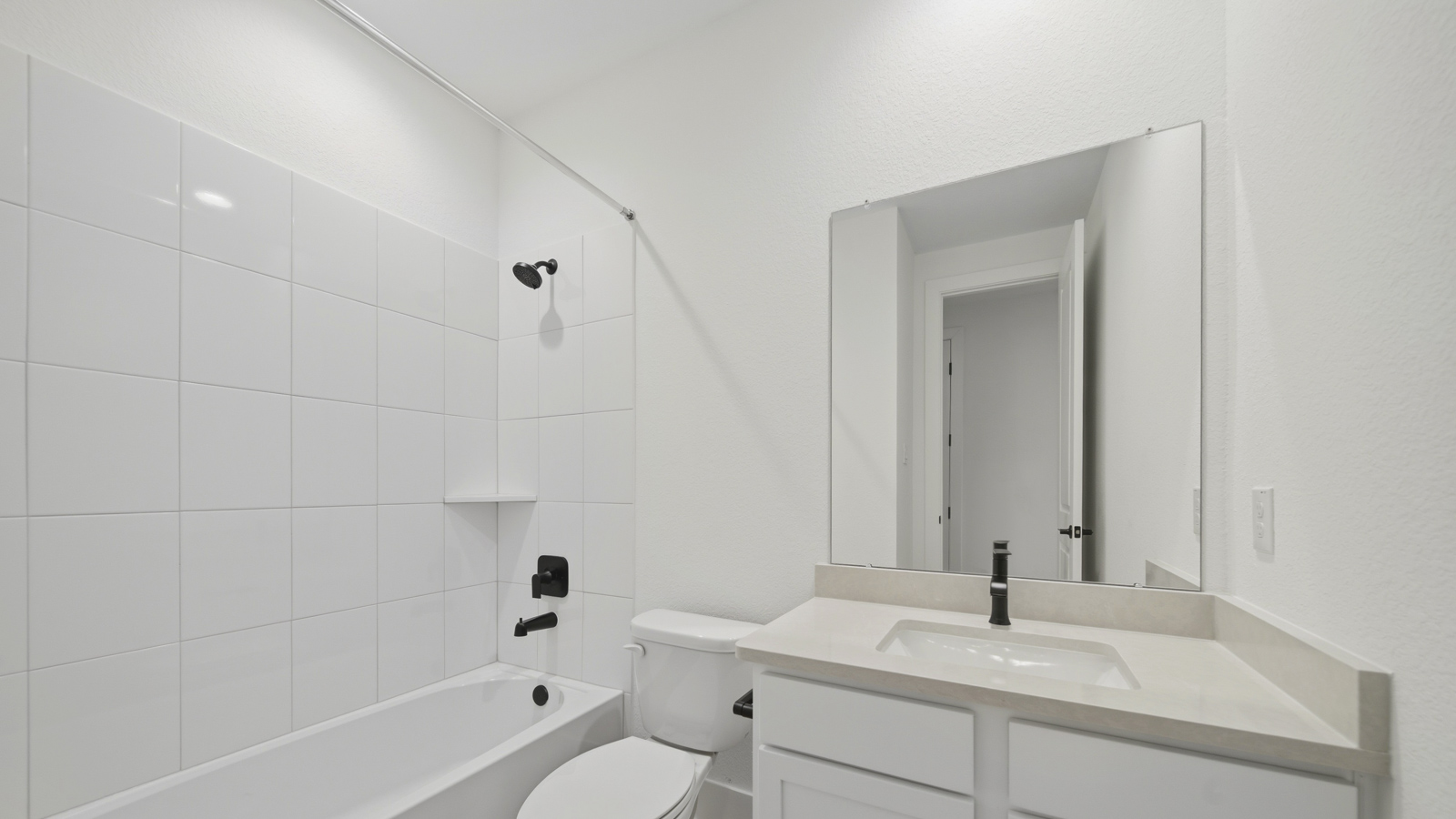 Secondary bathroom with tub/shower combo with quartz counter tops in Magnolia TX