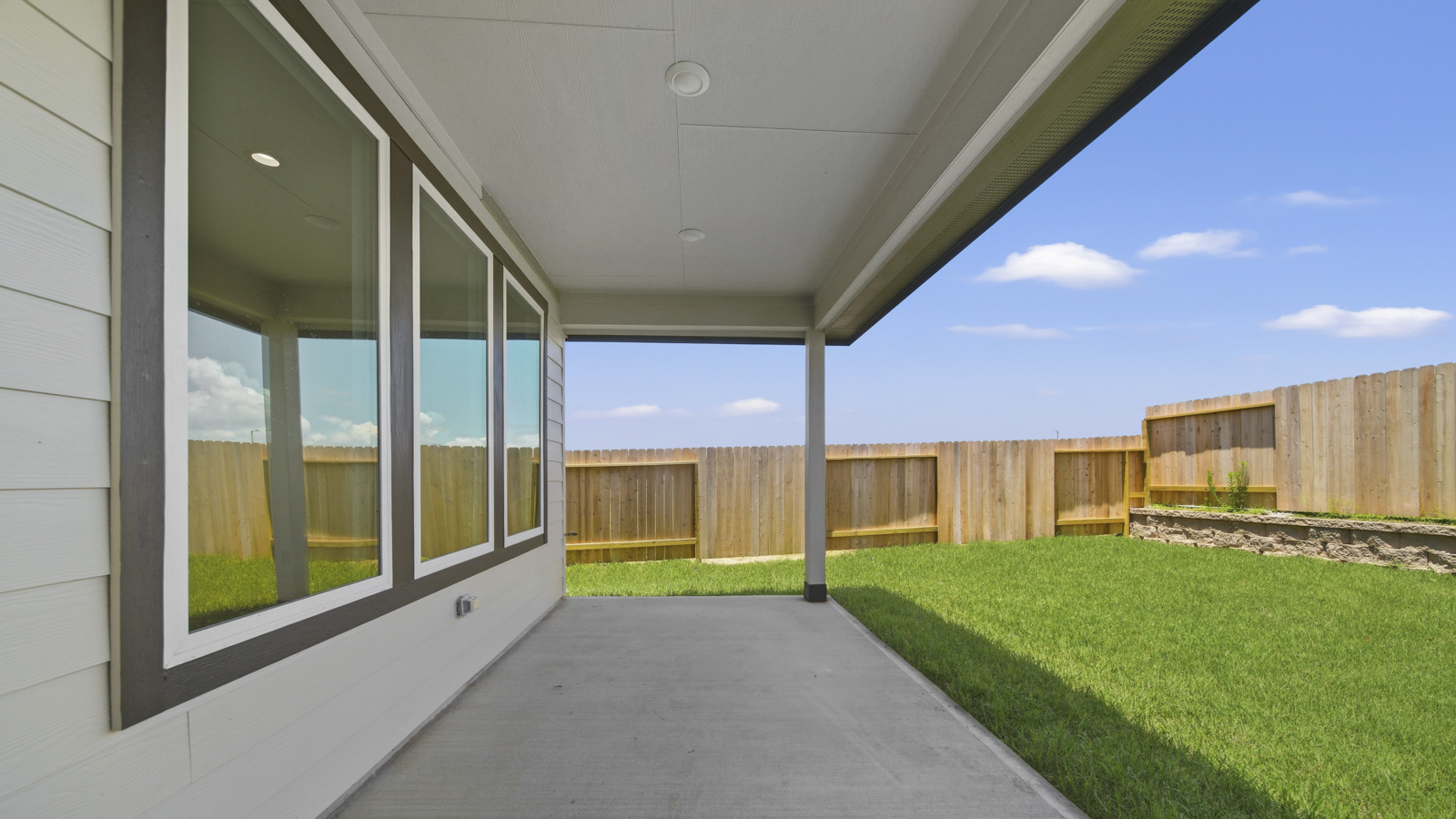 covered patio with jamies hardie siding and overhead lighting