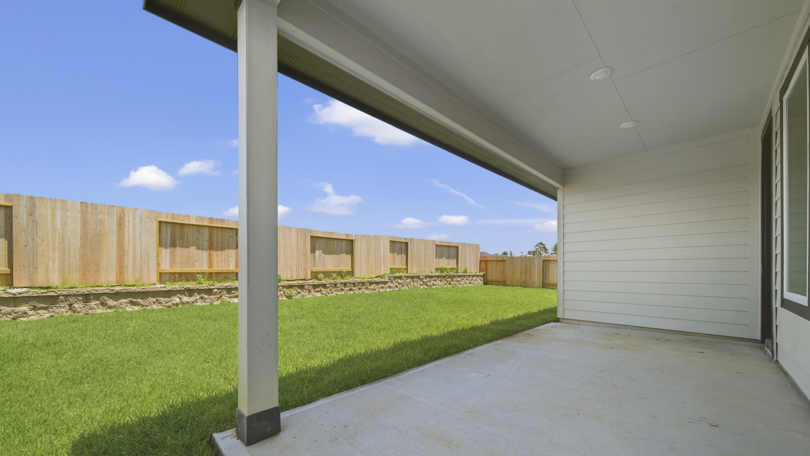 covered patio with jamies hardie siding and overhead lighting