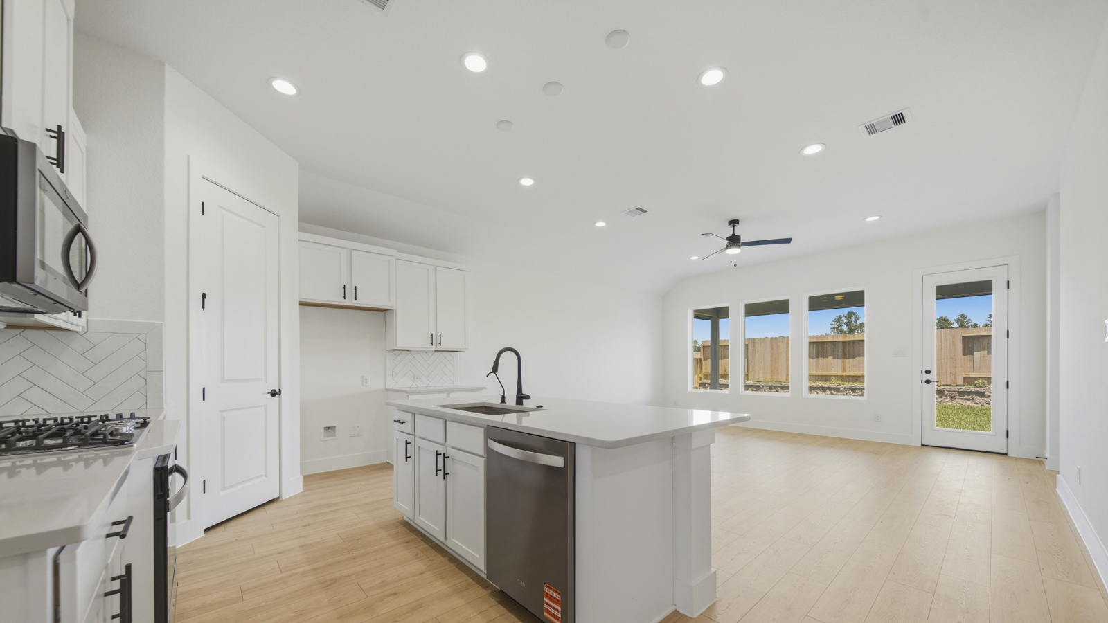 Kitchen with quartz countertops and marden hardware and an island and vinyl floor
