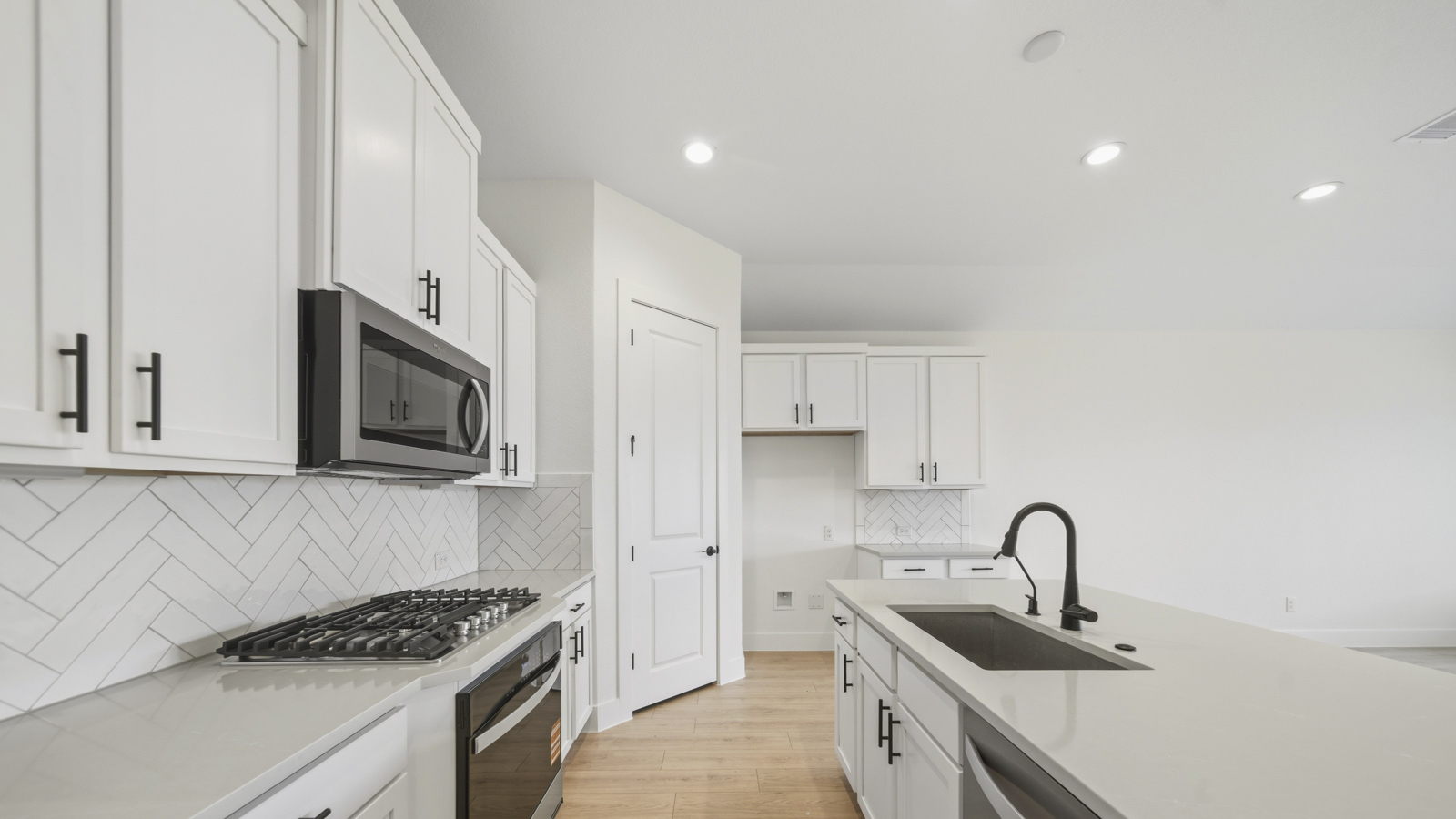 Kitchen with quartz countertops and marden hardware and an island and vinyl floor