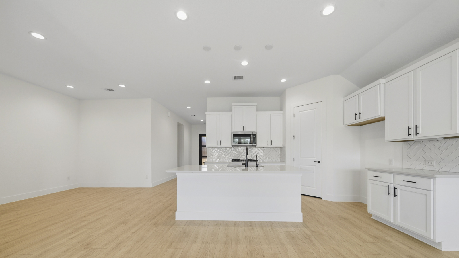 Kitchen with quartz countertops and marden hardware and an island and vinyl floor