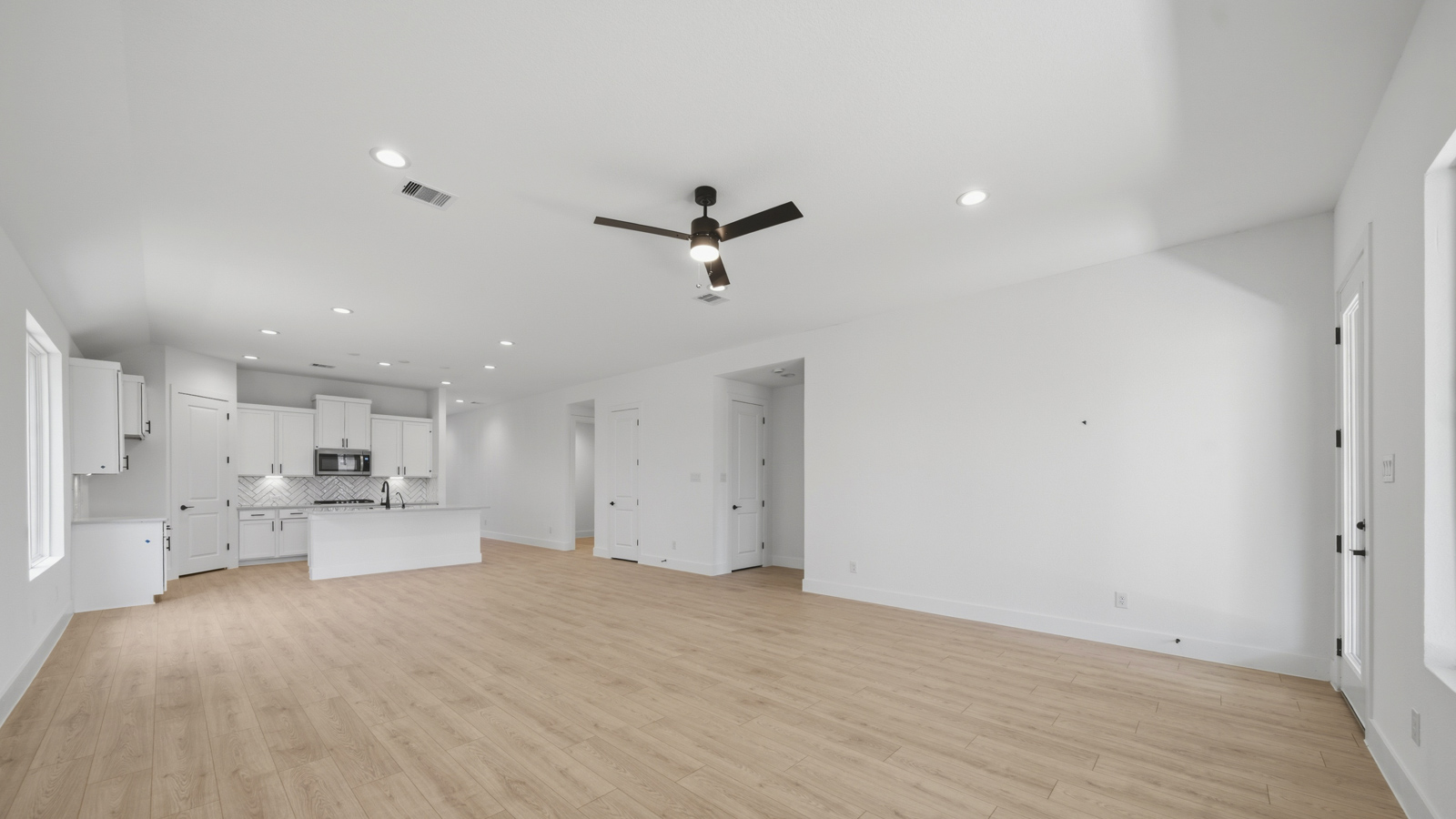 Spacious living area with vinyl flooring and bright windows in Magnolia TX